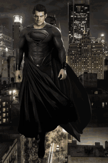 a man in a black superman costume is standing in front of a city skyline