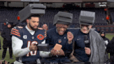 three nfl players wearing boxes on their heads with the number 10 on their jersey