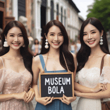 three asian women holding a sign that says museum bola