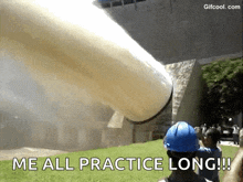 a man in a blue hard hat is standing in front of a large pipe that is blowing smoke .