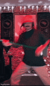 a man in a santa hat is dancing in a room with a red wall .
