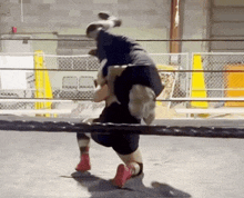 two men are wrestling in a ring and one of them is being lifted in the air