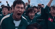 a group of people are standing in a field with their arms in the air and screaming .