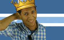 a man wearing a blue and white checkered shirt and a gold crown