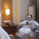 a man wearing a bunny hat is sitting in a chair