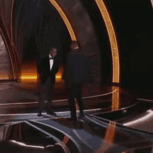 a man in a tuxedo is standing on a stage