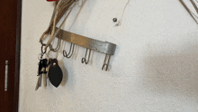 a bunch of keys are hanging on hooks on a wall