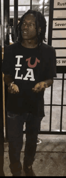 a man wearing a black shirt that says " i u la "