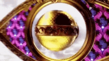 a close up of a gold and purple object in a gold frame