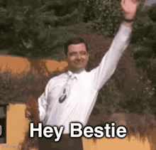 a man in a white shirt and tie is waving his hand and says hey bestie .