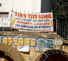 a sign for tiny tits school is hanging on a building