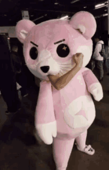 a person in a pink teddy bear costume is holding another person 's hand