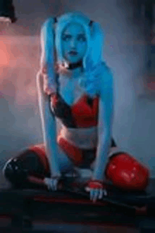 a woman in a harley quinn costume is sitting on a bench holding a bat .