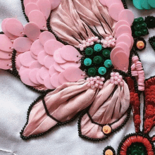 a pink flower with sequins and beads on it