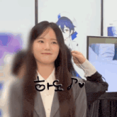 a woman in a suit and white shirt is smiling in front of a wall with a drawing of a boy on it