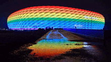 the allianz arena is lit up with a rainbow of lights