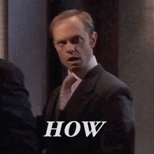 a man in a suit and tie is standing next to another man .