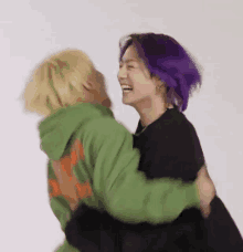 a man with purple hair is hugging a man with yellow hair .