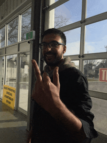 a man giving a middle finger in front of a sign that says rust proofing special starting at $ 26.99