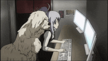 a woman is typing on a computer while a dog watches