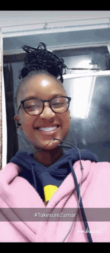 a girl wearing glasses and a pink hoodie has a selfie taken with the hashtag #takesurezamar