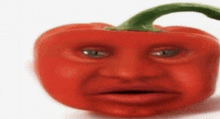 a red pepper with a face on it is sitting on a white surface .