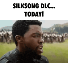 a man with a beard is standing in front of a crowd of people and says silksong dlc today !