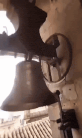 a bell is hanging from the side of a wall