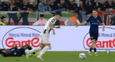 a soccer player is kicking a ball in front of a banner that says natural mineral water