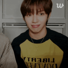 a young man wearing a yellow shirt that says " yt3bu " on it