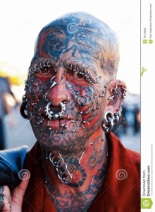 a man with a lot of piercings on his face and body