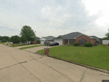 a black car is parked in front of a brick house in a residential area