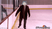 a man in a suit and tie is walking on a ice rink