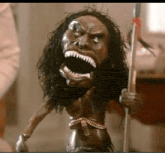 a statue of a native american holding a spear with a large mouth .