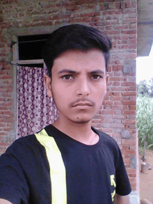 a young man in a black shirt with the letter n on it