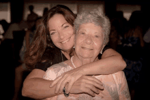 two women posing for a picture with one wearing pearls