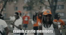 a group of young men are dancing in a park with the words `` crumb castle members '' in the foreground .