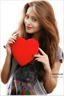 a woman is holding a red heart in front of her face and photolab.com is visible in the corner