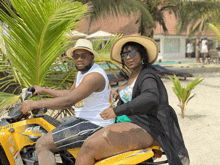 a man and a woman are riding a can-am atv on a beach