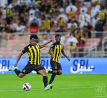 a man in a yellow and black striped shirt kicking a ball