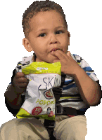 a young boy holds a bag of skin popcorn