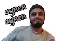 a man with a beard is wearing a white shirt and a black hat and has aynen aynen written on his face