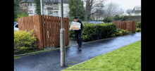 a man is carrying a large tray of food on a sidewalk