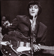 a man is singing into a microphone while playing a guitar