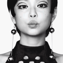 a black and white photo of a woman with earrings