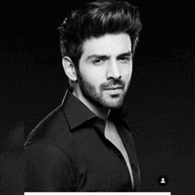 a black and white photo of a young man with a beard
