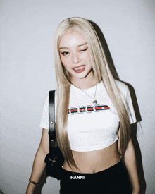 a woman wearing a white crop top with gucci written on it