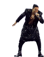 a man is singing into a microphone while wearing a sequined suit