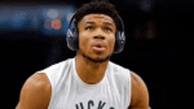 a basketball player wearing headphones is looking up .