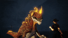 a woman in a cowboy hat is standing next to a giant dinosaur